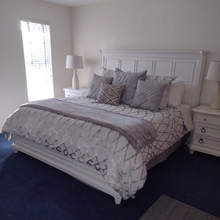 White king-size bed with gray bedding, pillows and nightstands