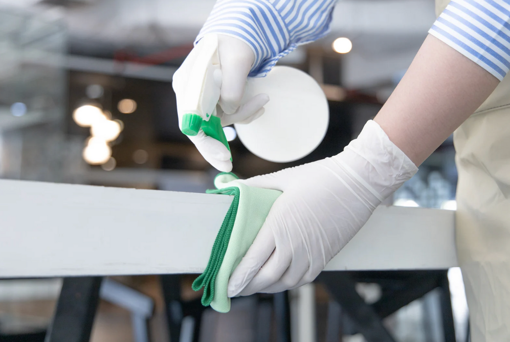 Cleaning lady wiping down table