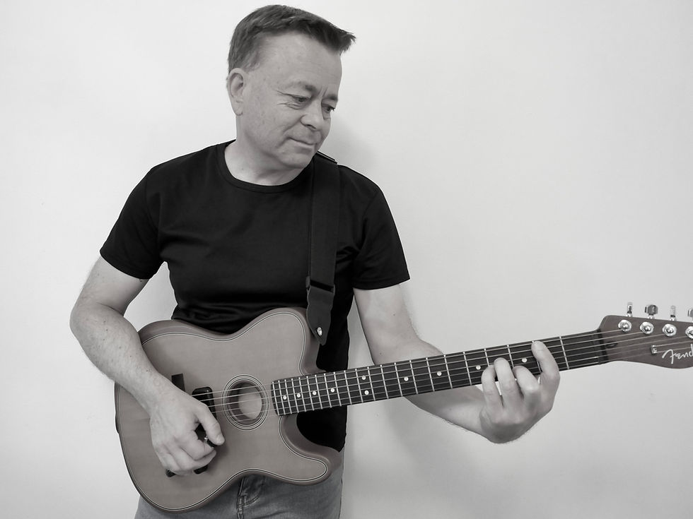 Portrait of Simon Ward playing acoustic guitar