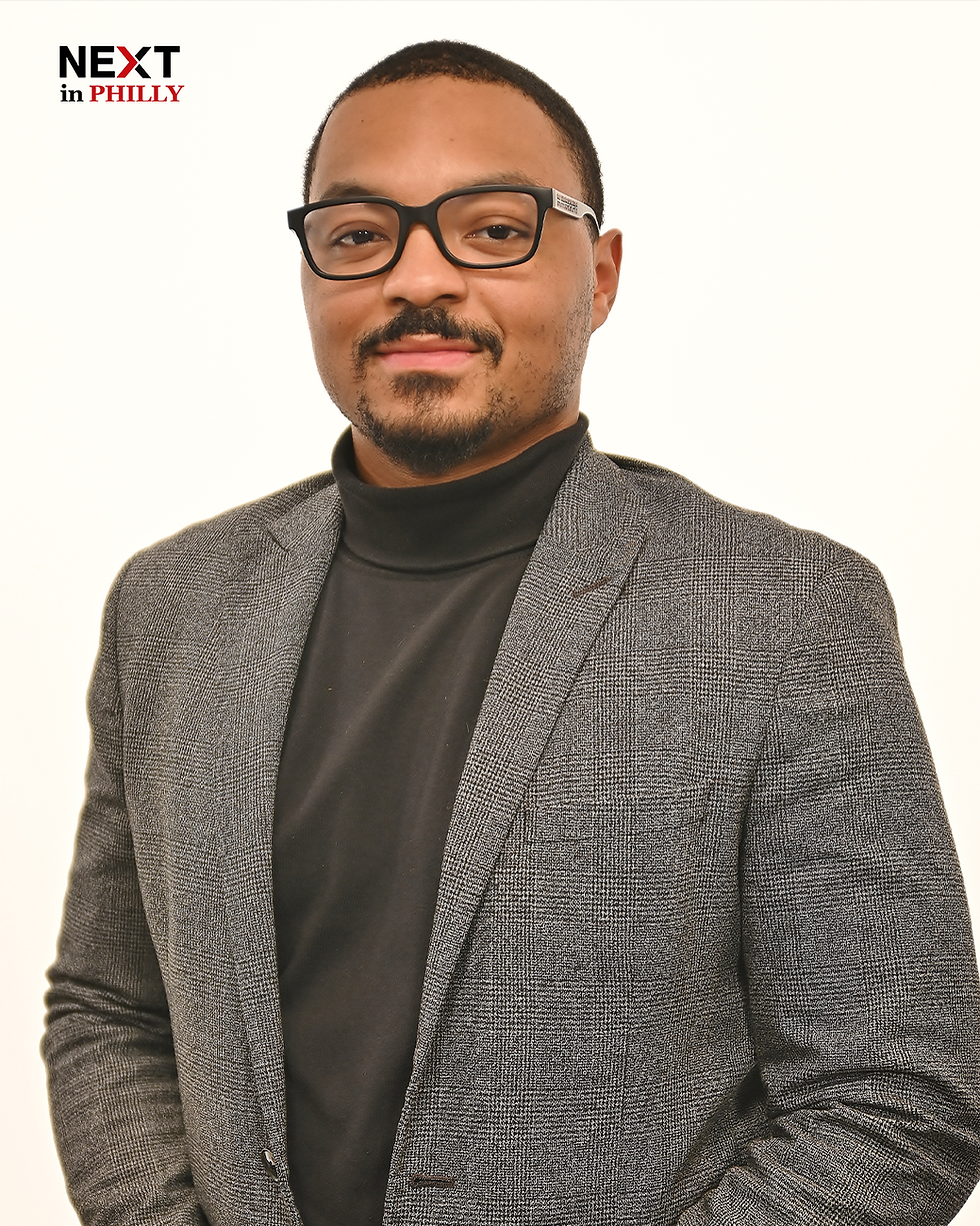 Rishaun Hall, President of Young Involved Philadelphia, wearing a gray blazer and black turtleneck against a neutral background