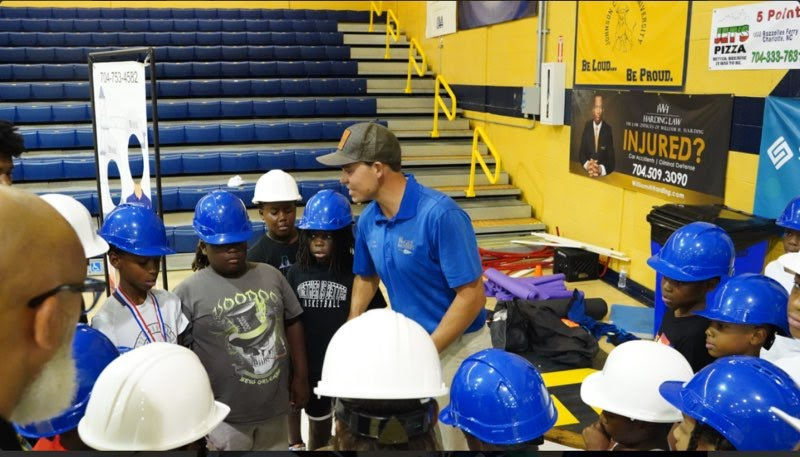 CLT Impact Instructor coaching kids on a group activity.