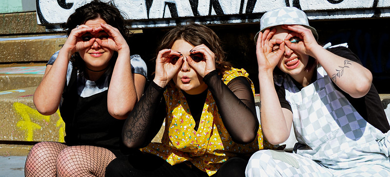 three models use hands as binoculars to look right at you