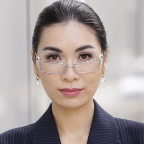 Professional woman with dark hair and light skin wearing business appropriate makeup and sleek, pulled back hair