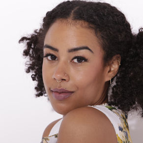 Closeup of a woman with dark hair and dark skin wearing natural, daytime makeup