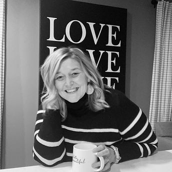 board member with long blond hair, smiling and holding a coffee mug
