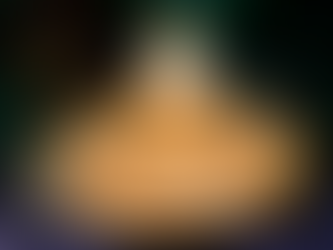 Festive dessert topped with whipped cream and Halloween sprinkles sits on a plate. Includes candy pumpkins. Dark, spooky background.