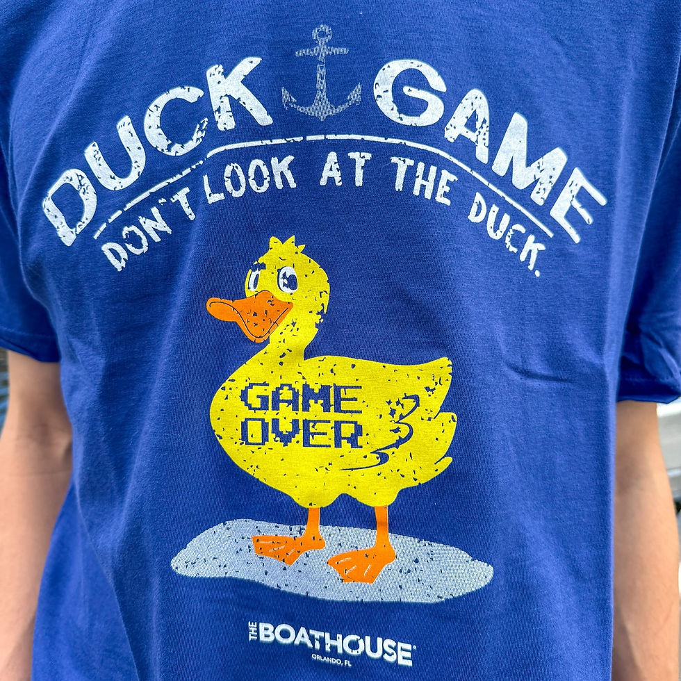 Close-up of a blue shirt with a yellow duck and "Game Over" text. Above are the words "Duck Game, Don't Look at the Duck."