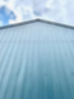 the most modern, beautiful, blue, 2-storey boatshed against a blue sky