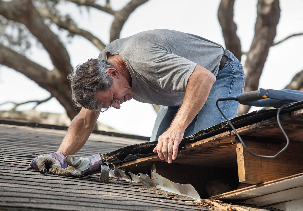 Man on roof fixing damage