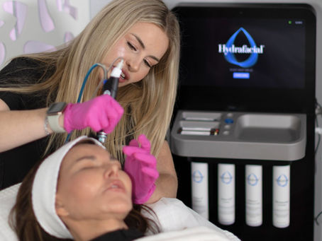 Woman giving a female customer a HydraFacial treatment at Veltori Hair & Aesthetics in Burlington.