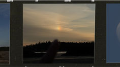A film strip of photos at the beach. The far left shows Long Beach, Tofino with a full moon floating in the sky. The middle image is a finger pointing at a sundog hovering over the beach, and the far right image is a close up of the moon.