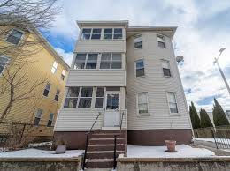 Eye-level view of a residential street with well-maintained homes and mature trees in Central Massachusetts