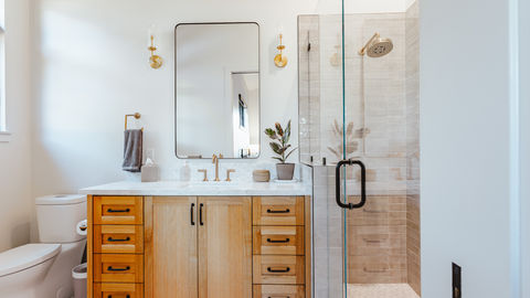 a bathroom with wooden cabinets and a walk in shower