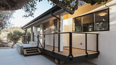 a white house with a black railing and stairs