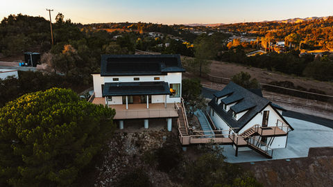 an aerial view of a house with solar panels on the roof