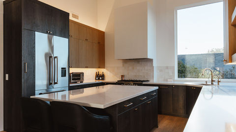 a kitchen with a large island and a stainless steel refrigerator