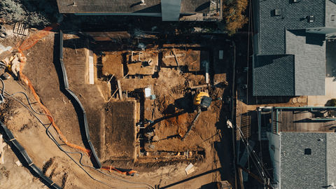 an aerial view of a construction site with a yellow excavator