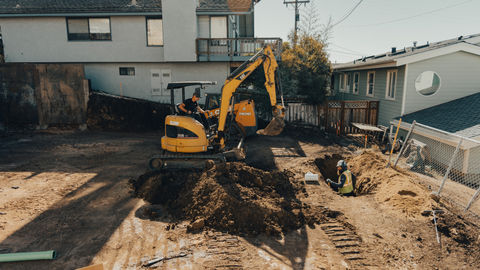 a yellow cat excavator is digging a hole in the dirt