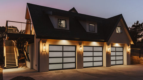 a house with a black roof and white garage doors