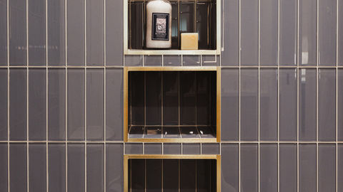 a bottle of lotion sits on a shelf in a bathroom