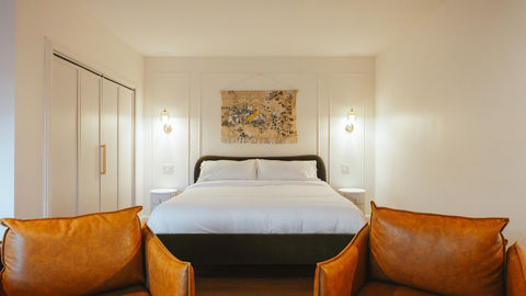 a bedroom with a large bed and two chairs