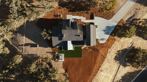 an aerial view of a house with solar panels on the roof