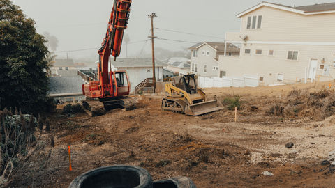 a yellow cat bulldozer sits in a dirt field