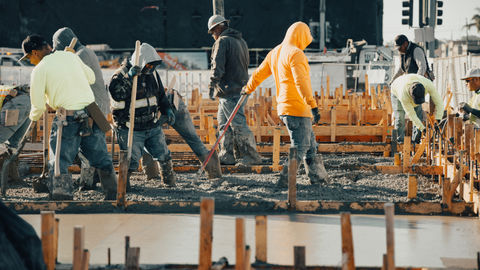 a group of construction workers are working on a concrete floor