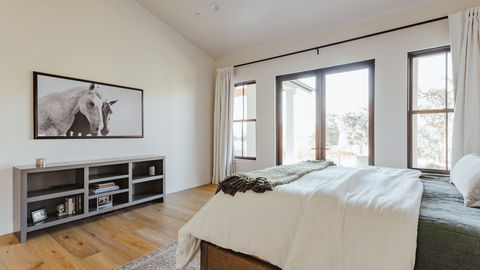 a bedroom with a bed and a picture of a horse on the wall