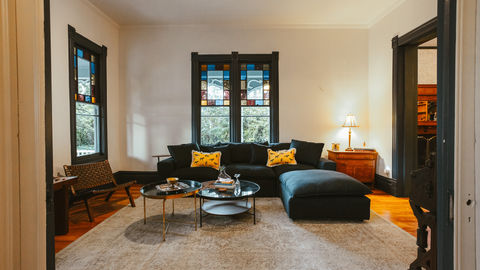 a living room with a black couch and two coffee tables