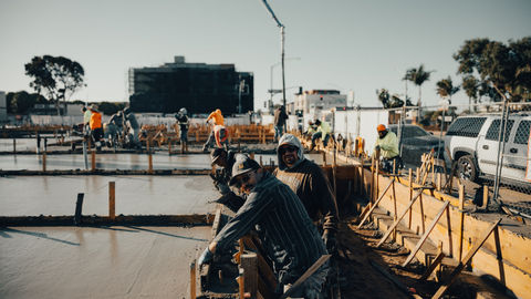 a group of construction workers are working on a concrete floor