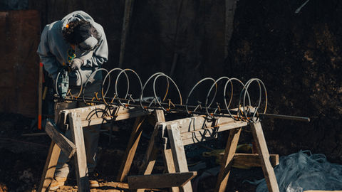 a man wearing a mask is working on a piece of metal