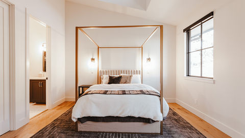 a bedroom with a canopy bed and a window