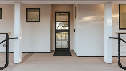 a white house with a black door and a black mat