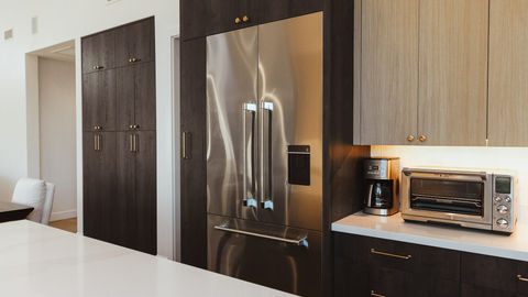 a stainless steel refrigerator in a kitchen next to a coffee maker