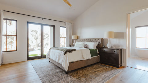 a bedroom with a large bed and a ceiling fan