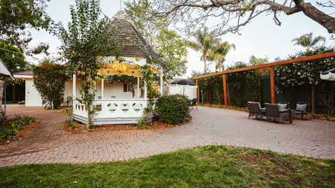 a white gazebo with a wooden roof and a chandelier