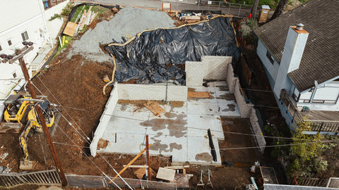 hillside home under construction concrete foundation and retaining wall