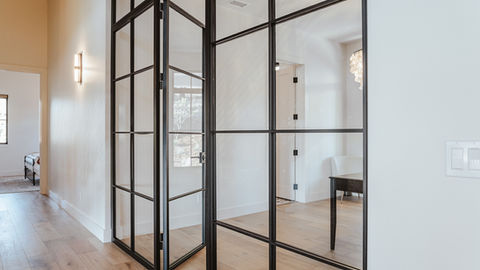a room with a table and chairs and a glass wall
