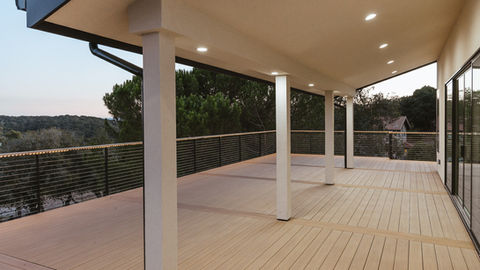 an empty deck with a fence and pillars surrounding it