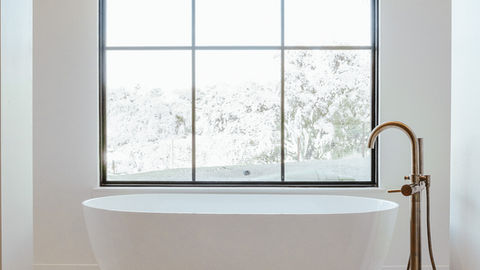 a bathtub in a bathroom with a large window