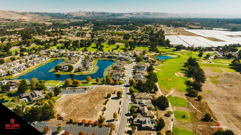 an aerial view of a residential area with a golf course in the background
