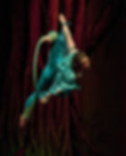 Franni hanging from a lyra, looking back at the camera