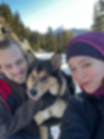Franni and Charles in the snow with their dog Raya between them.