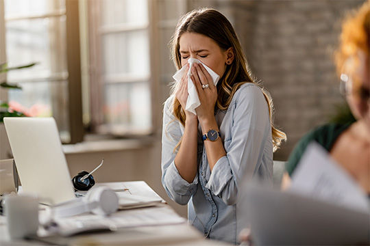 Pessoa com gripe no trabalho