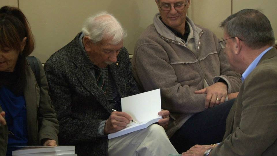Veteran Keith Norrish signs a copy.
