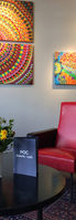 Intérieur de café avec des tableaux colorés et un fauteuil rouge, POC