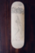 Pen drawing on skateboard deck of whale under water.