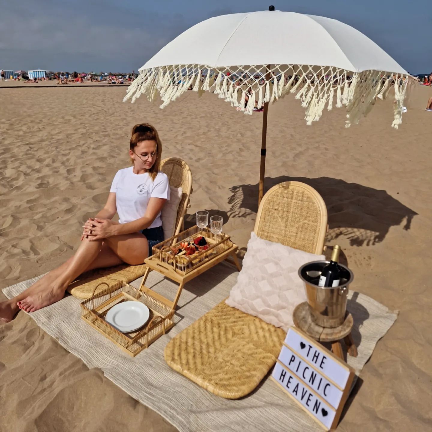blonde girl sitting at the beach and stylish beach setup