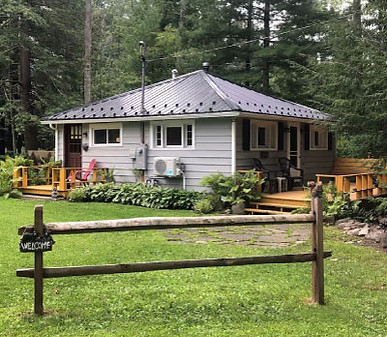 Small cabin with cute front porch and rustic fence